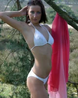 Exciting chick in white bikini showing her sexy body in the forest