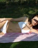 Exciting chick in white bikini showing her sexy body in the forest