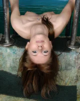 Teen in mini black bikini swimming in the pool