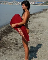 On the beach in black bikini with the nipples puffy