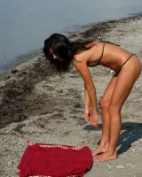 On the beach in black bikini with the nipples puffy