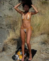 A brunette with puffy nipples and tasty ass in white sexy bikini in the field