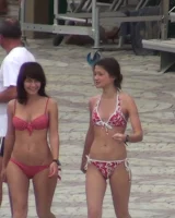Candid chicks walking on the beach in sexy bikinis