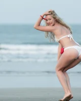 Girl in white bikini and topless on the beach
