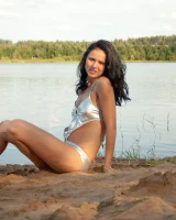 Teen in silver bikini swimming in the lake