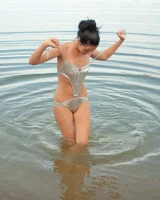 Teen in silver bikini swimming in the lake