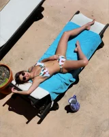 Hot brunette in white bikini with pineapples and black sunglasses has puffy nipples