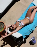 Hot brunette in white bikini with pineapples and black sunglasses has puffy nipples