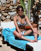 Hot brunette in white bikini with pineapples and black sunglasses has puffy nipples