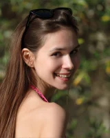Young slim body brunette beauty is by the pool in polka dot pink bikini with sunglasses