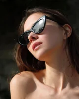 Young slim body brunette beauty is by the pool in polka dot pink bikini with sunglasses