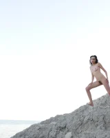 Hairy pussy brunette with puffy nipples wears red dotted bikini and strips to show her remarkable nude body at the rocks