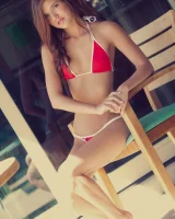 Puffy nipples beauty on the wooden chair in mini bikini