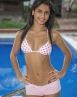 Perfect young latin chick is by the pool in white dotted bikini covering erected nipples